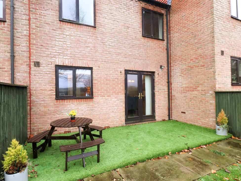 A garden with a table and chairs at Bumblebee Cottage in Whitby