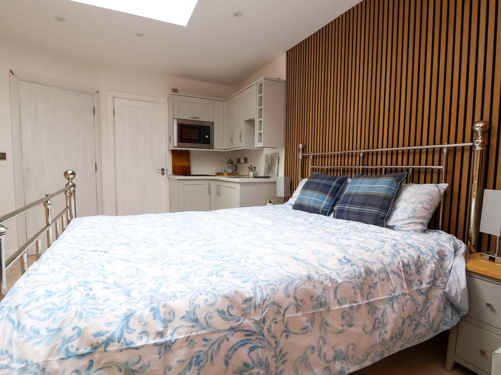 A bedroom with a bed and kitchenette at Skylights Chester