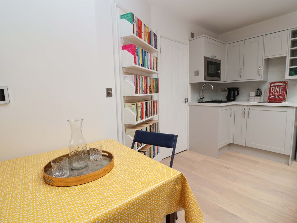 A kitchen with a table and bookshelves at Skylights in Hoole