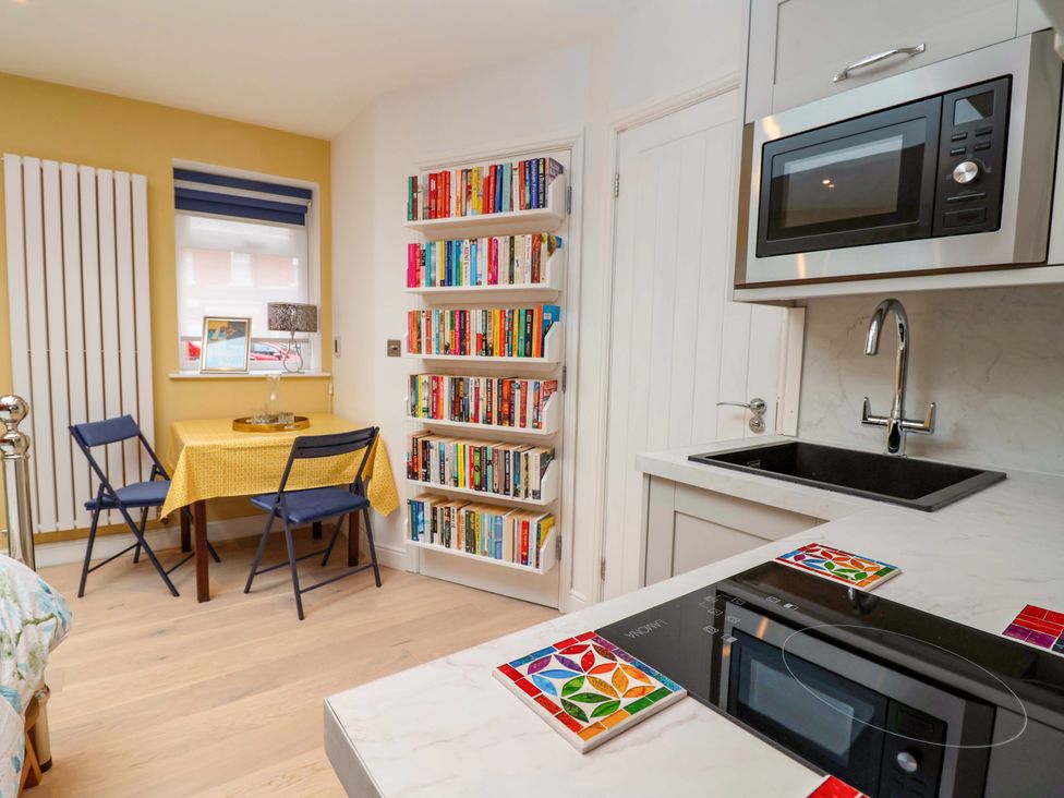 A kitchen with a table and chairs and a microwave at Skylights in Hoole