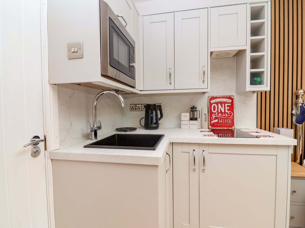 A kitchen with a sink and microwave at Skylights in Hoole