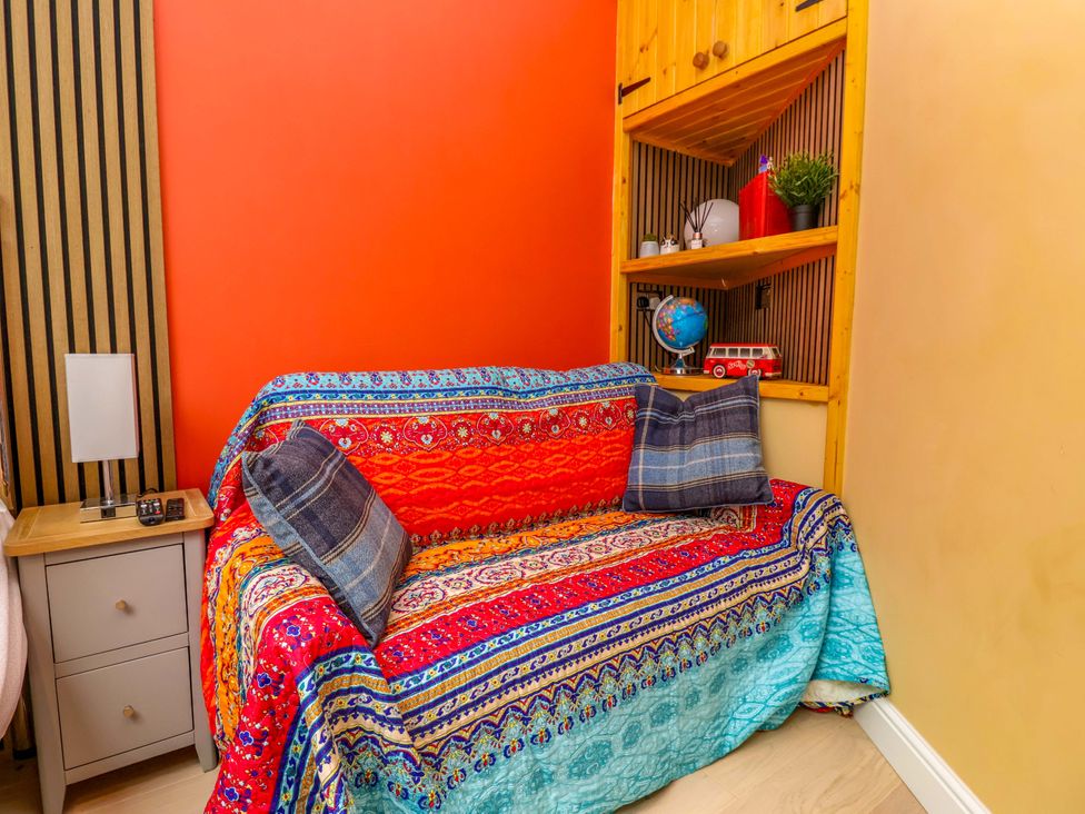 A living room with a sofa and shelves at Skylights in Hoole