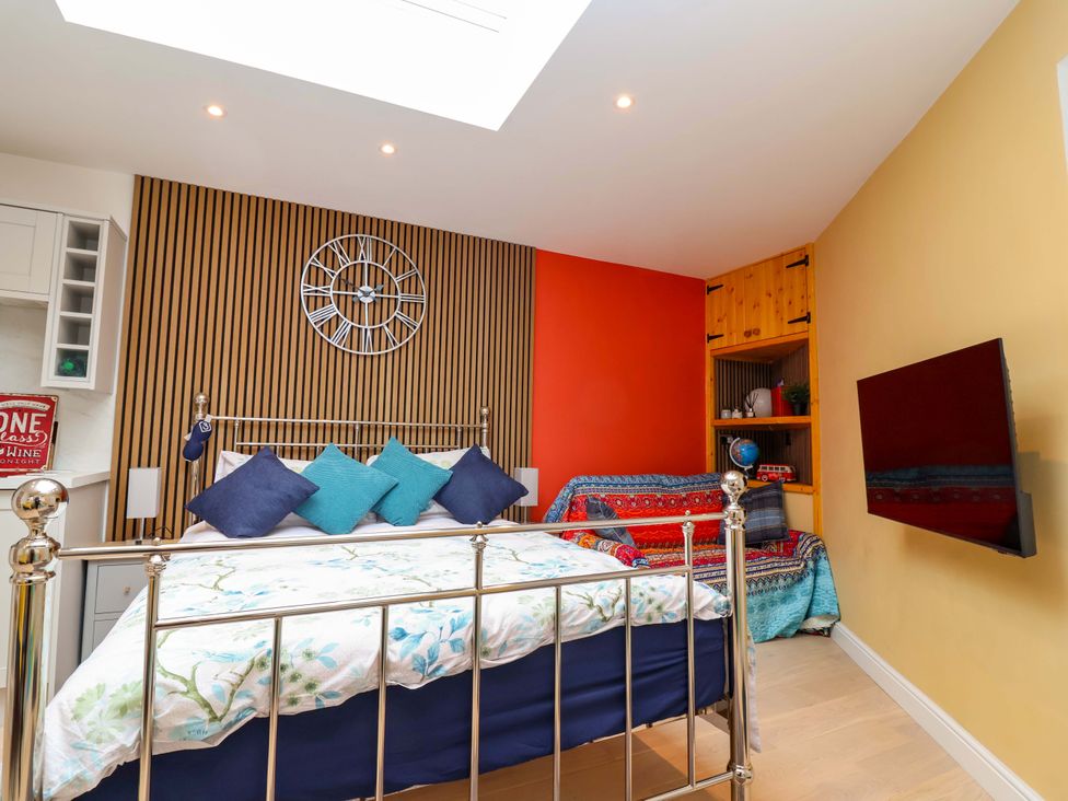 A bedroom with a bed and wall-mounted TV at Skylights in Hoole
