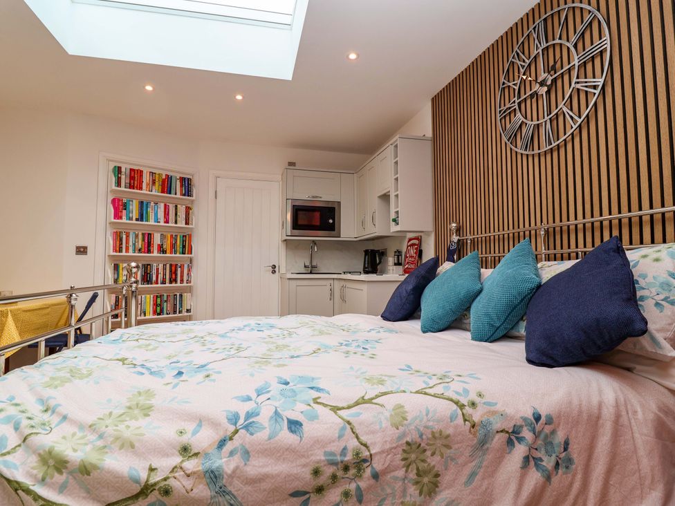 A bedroom with a bed and a bookshelf at Skylights in Hoole