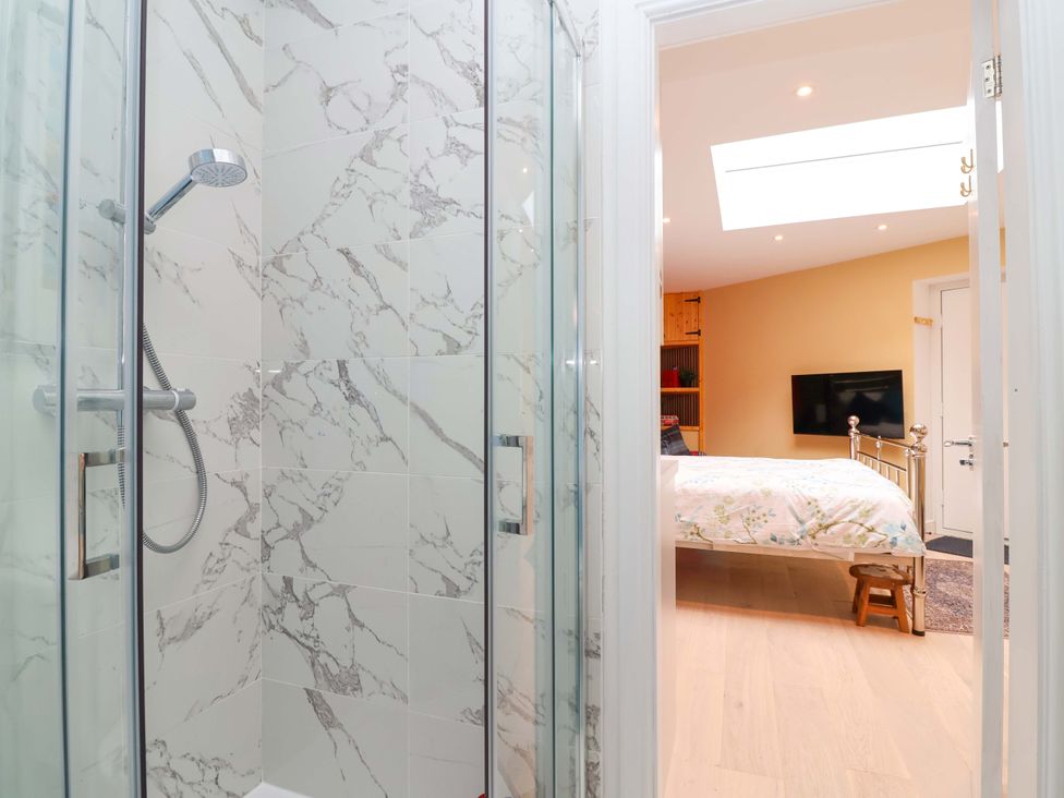 A bathroom with a shower and view of a bedroom at Skylights in Hoole