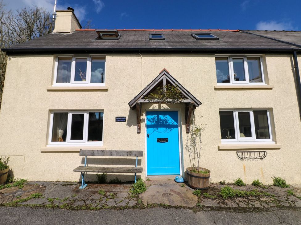 A house with blue door and bench at 1 Mill Farm Cottages in Narberth