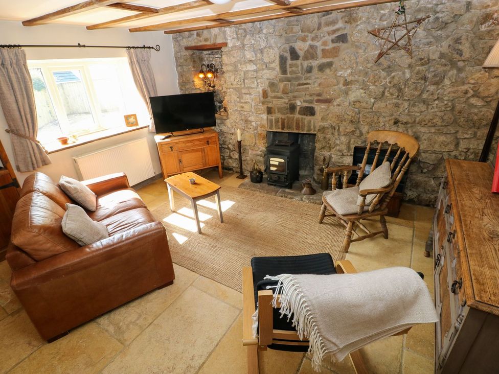 A living room with a sofa, coffee table, and television at 1 Mill Farm Cottages Narberth