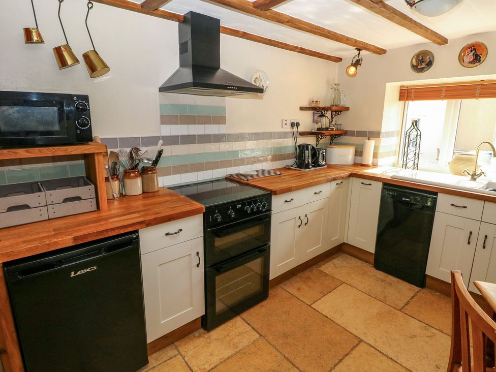 A kitchen with appliances and wooden countertops at 1 Mill Farm Cottages in Narberth