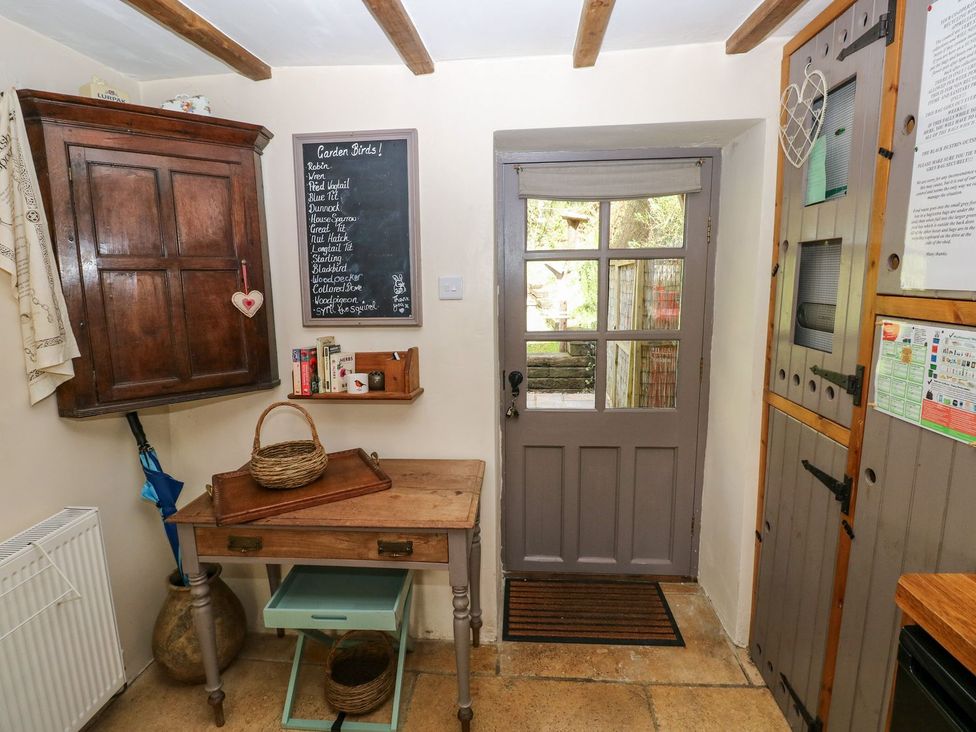A kitchen with a table and door at 1 Mill Farm Cottages in Narberth