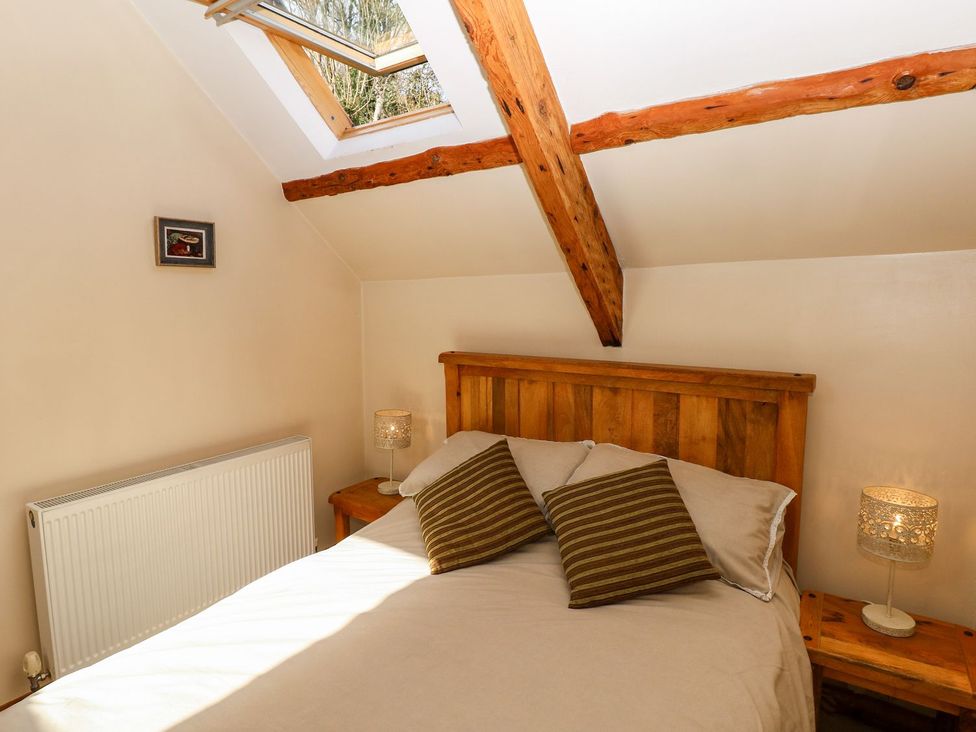 A bedroom with a double bed and skylight at 1 Mill Farm Cottages in Narberth