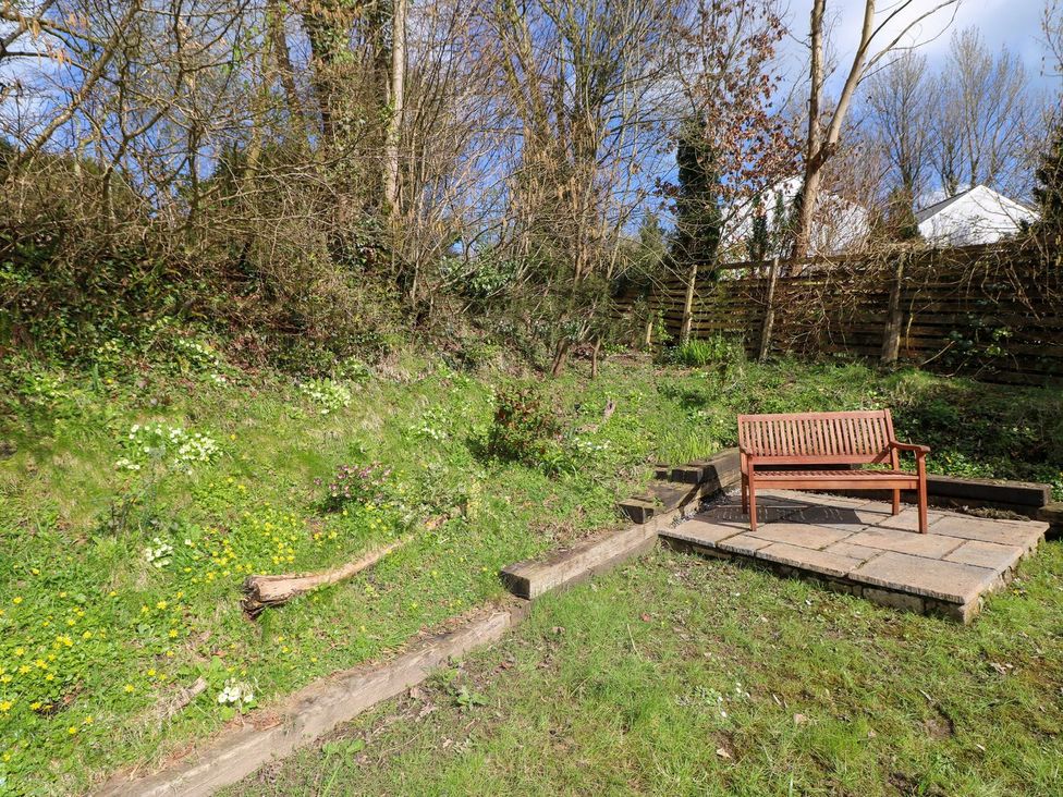 A garden with a bench and flowers at 1 Mill Farm Cottages in Narberth