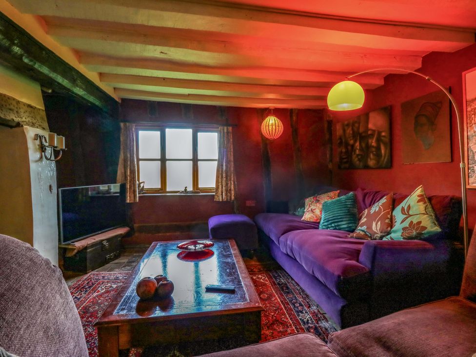A living room with a purple sofa and television at Town Farm in 