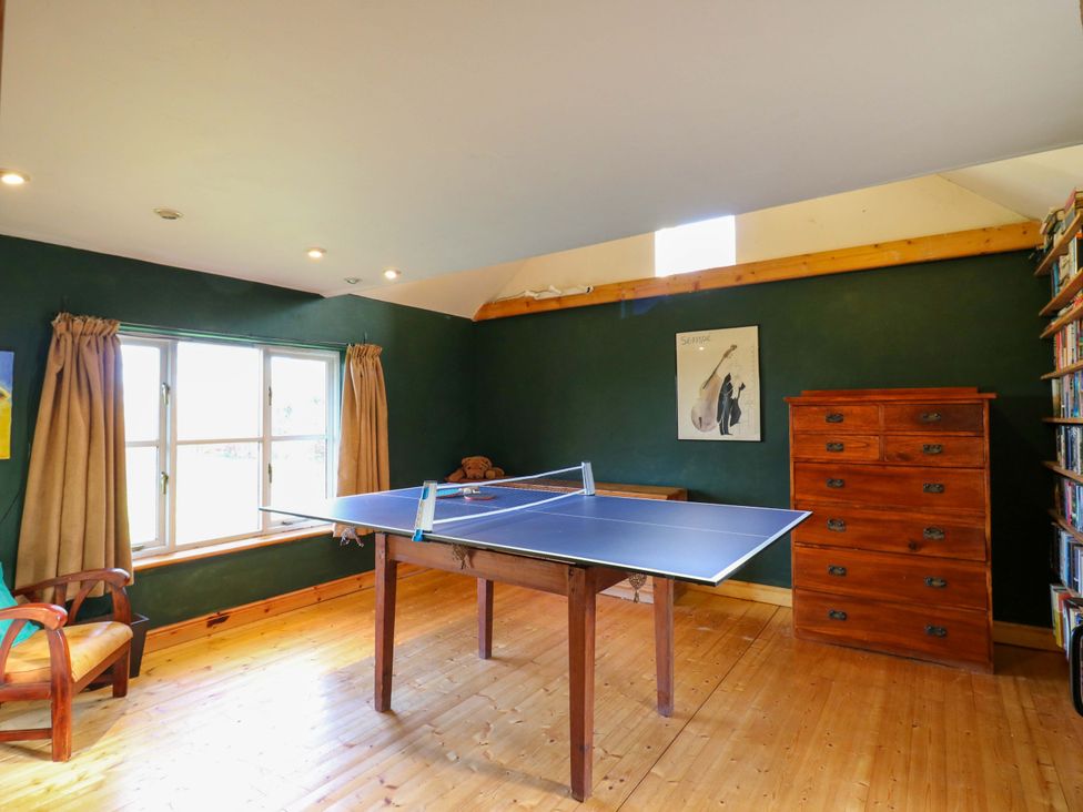 A game room with a ping pong table and a bookshelf at Town Farm in 