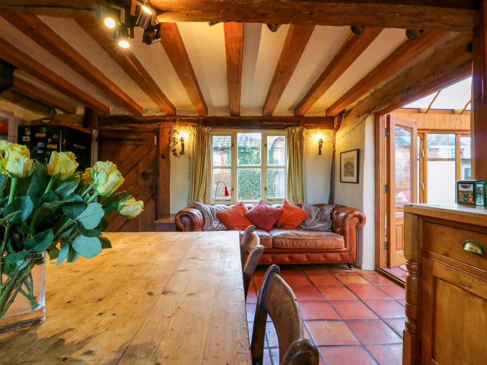 A kitchen with a dining table and a brown sofa at Town Farm
