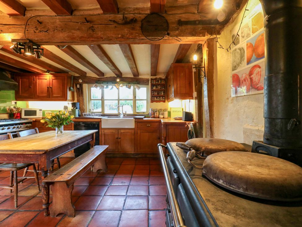 A kitchen with wooden cabinets and a dining table at Town Farm