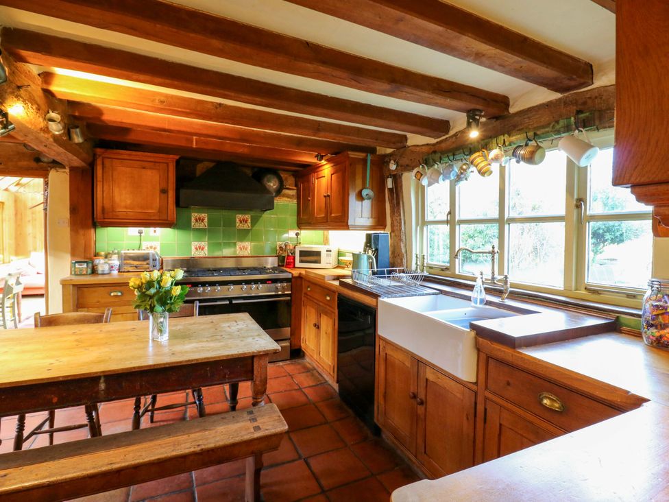 A kitchen with wooden cabinets and a table at Town Farm in 