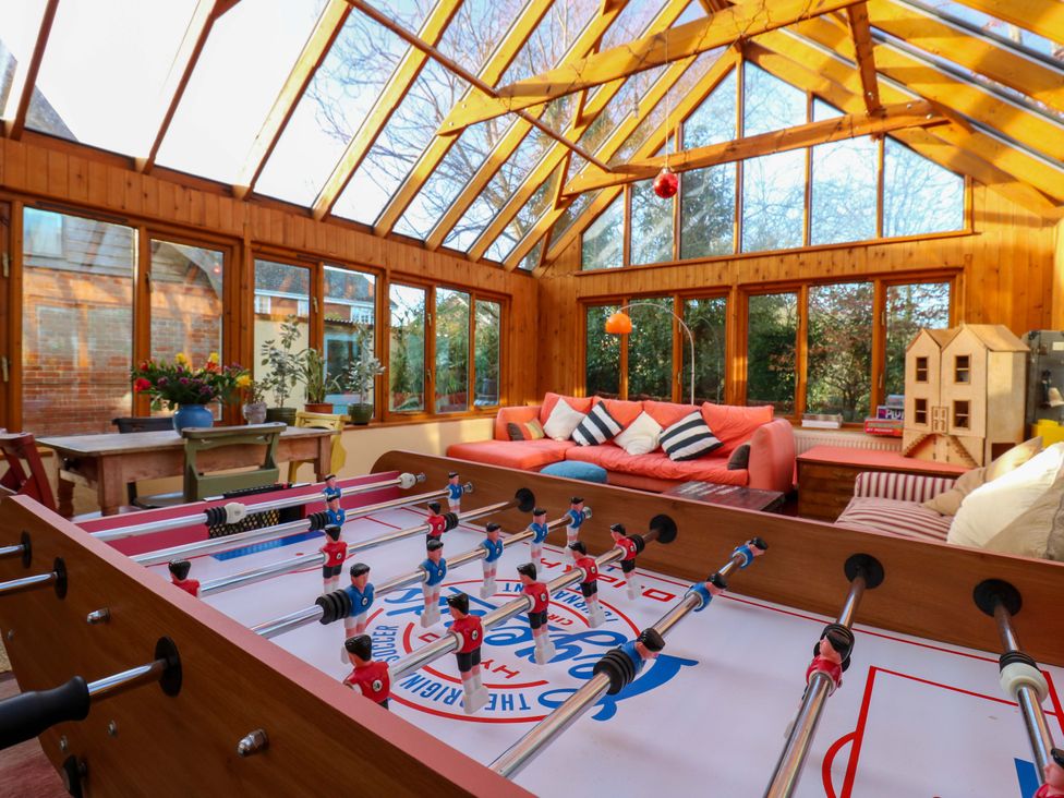 A conservatory with a foosball table and seating area at Town Farm