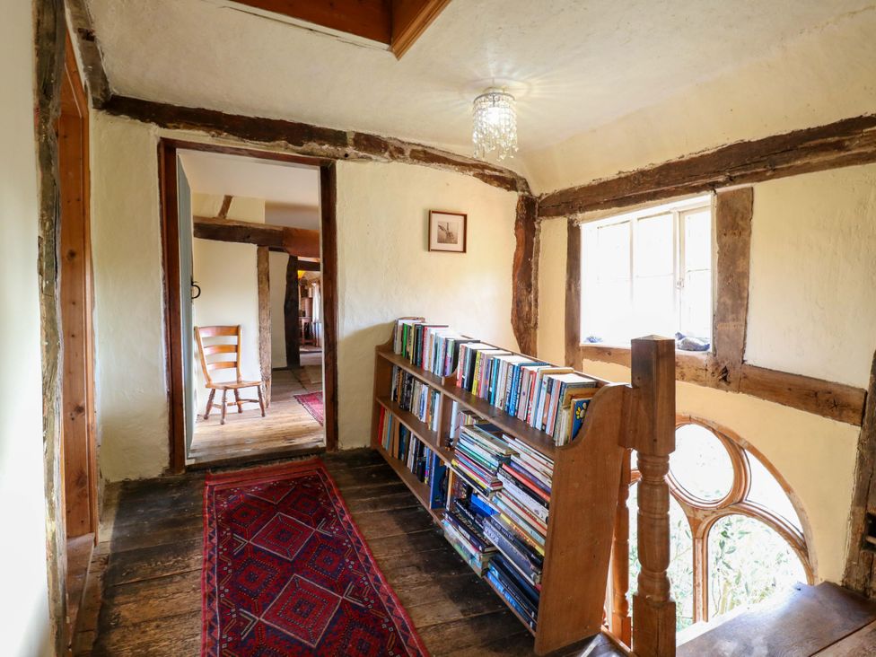 A hallway with a bookshelf and a chair at Town Farm
