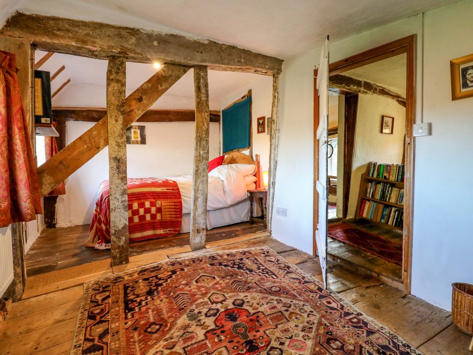 A bedroom with a rug and bookshelf at Town Farm in 