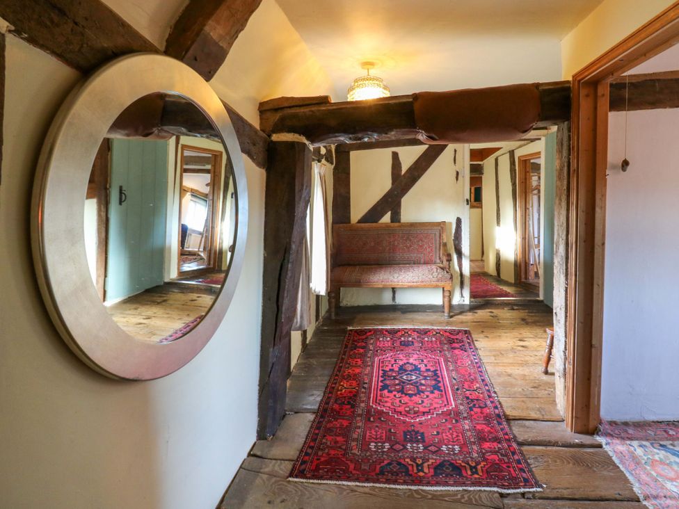 A hallway with a mirror, bench, and rug at Town Farm in 