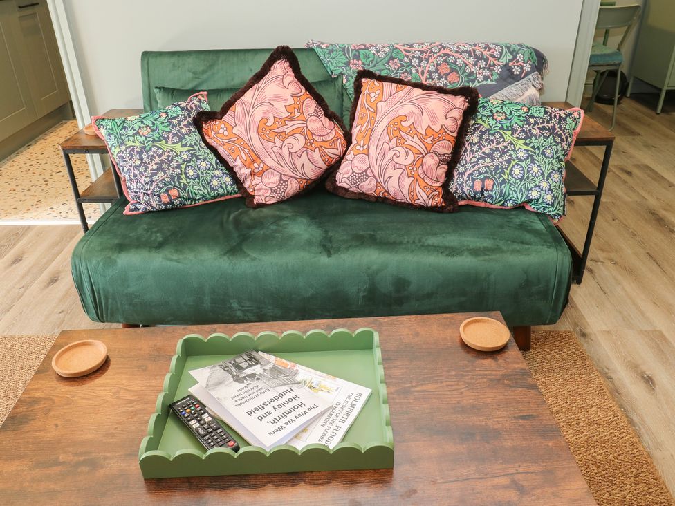 A living room with a green sofa and patterned throw pillows at Underview in Jackson Bridge