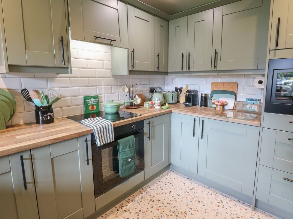A kitchen with cabinets, stove, sink, and various kitchen utensils at Underview in Jackson Bridge