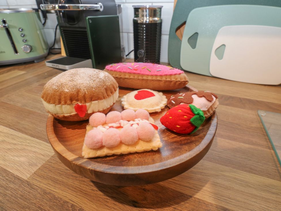 A wooden plate with various felt sweets in the kitchen at Underview in Jackson Bridge