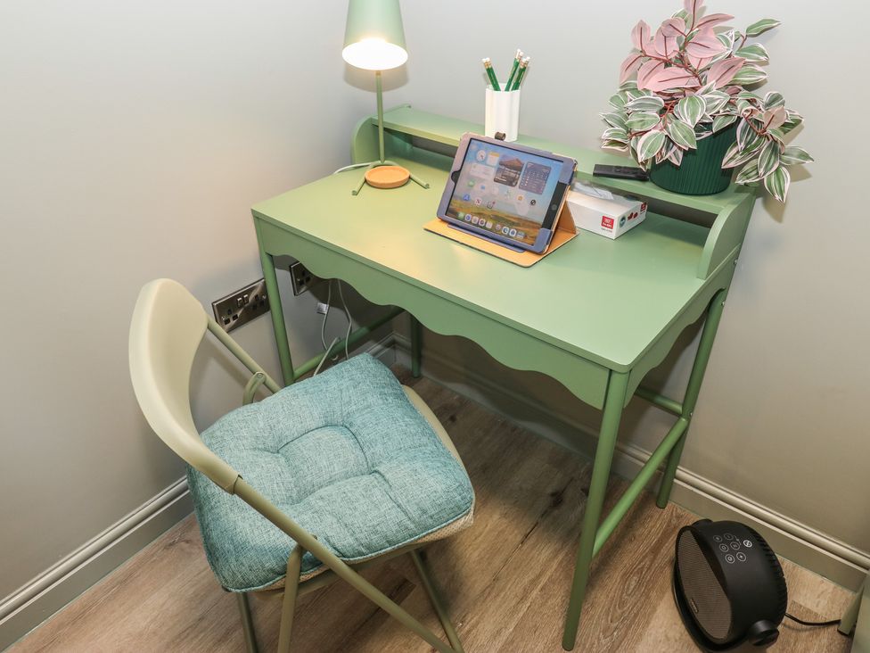 A home office with a desk, chair, lamp, tablet, and plant at Underview in Jackson Bridge