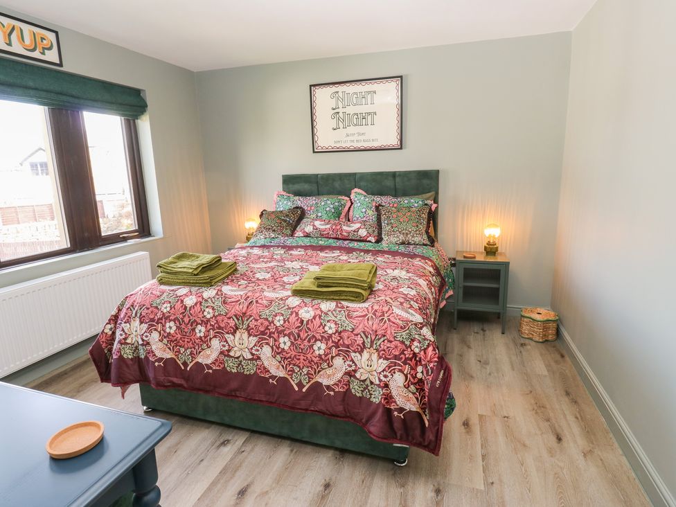 A bedroom featuring a bed with a floral bedspread at Underview in Jackson Bridge
