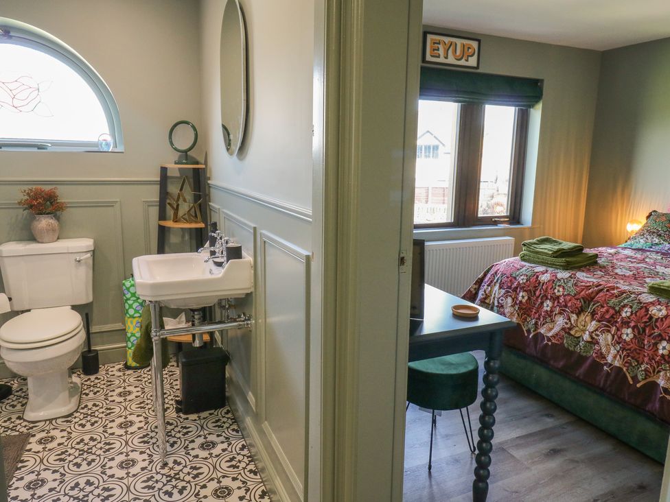A bathroom with a toilet and sink adjacent to a bedroom at Underview in Jackson Bridge