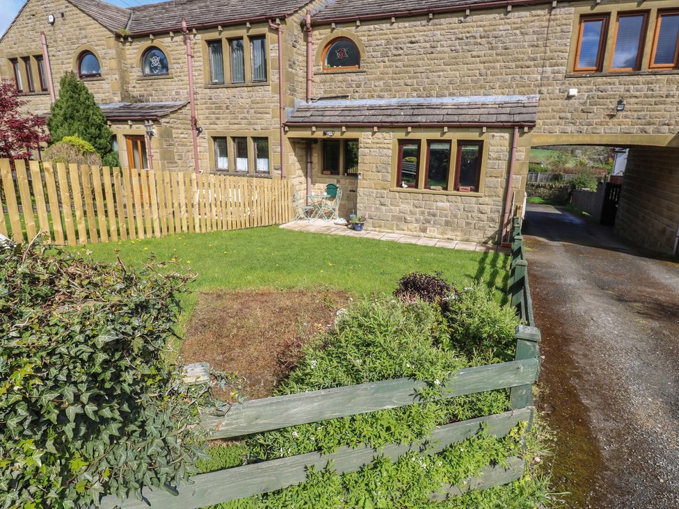 A garden with grass, a fence, and a chair at Underview in Jackson Bridge