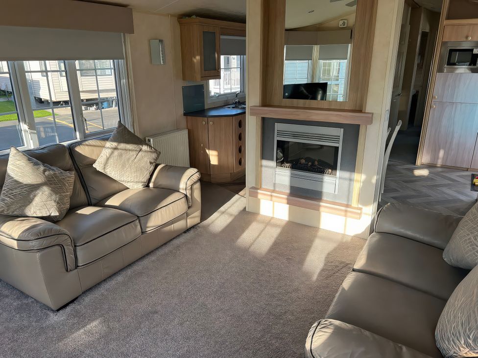 A living room with sofas and a fireplace at Gainc Bach in Abergele