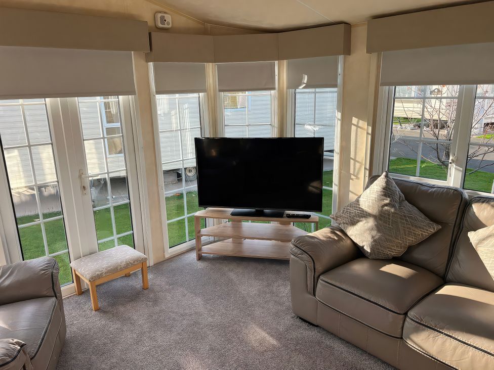 A living room with a television and sofa at Gainc Bach in Abergele