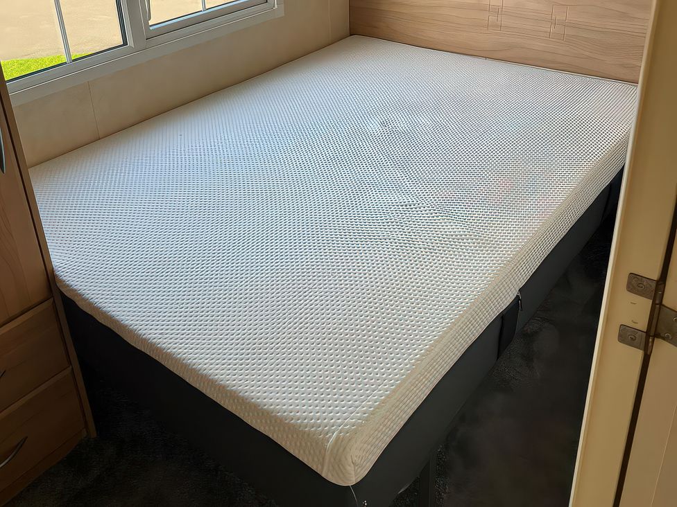 A bed with a mattress in a bedroom at Gainc Bach Abergele