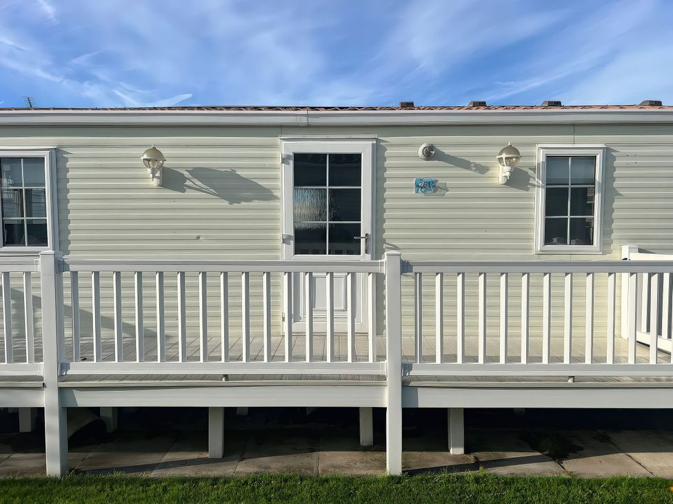 An outdoor view of a mobile home with a deck at Gainc Bach in Abergele