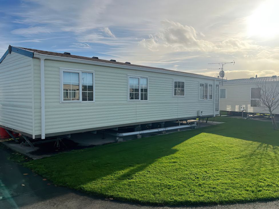 A mobile home with green grass and windows at Gainc Bach Abergele