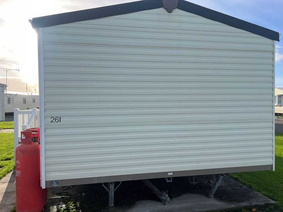A caravan with a gas bottle beside it at Gainc Bach in Abergele
