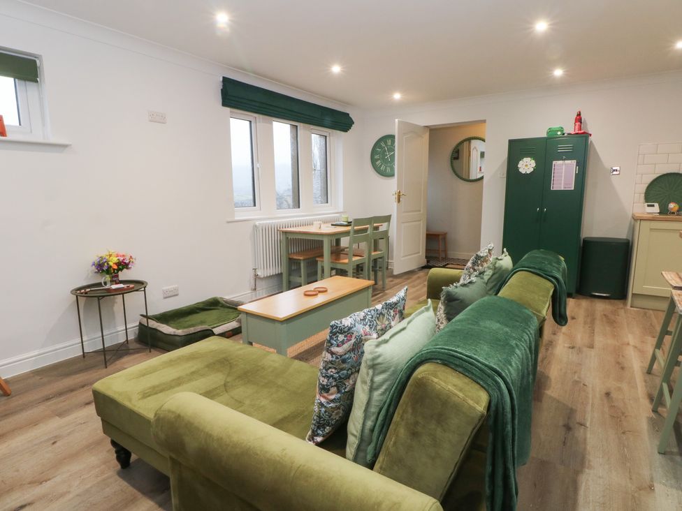 A living room with a sofa and dining table at 4 Downshutts Lane Holmfirth