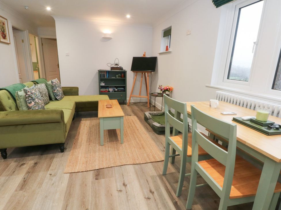 A living room with a sofa, coffee table, and dining area at 4 Downshutts Lane Holmfirth