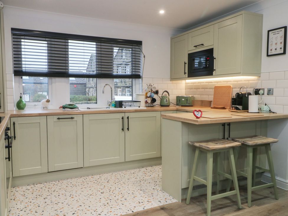 A kitchen with a sink and microwave at 4 Downshutts Lane Holmfirth