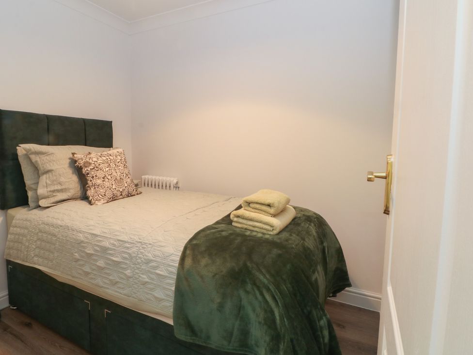 A bedroom with a bed and towels arranged at 4 Downshutts Lane in Holmfirth