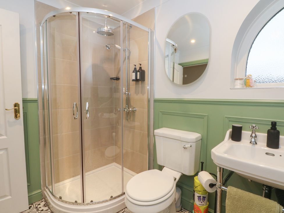 A bathroom with a shower, toilet, and sink at 4 Downshutts Lane in Holmfirth