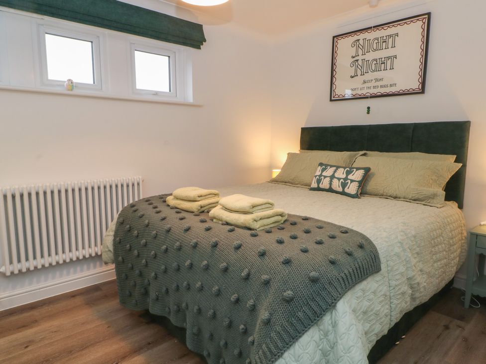 A bedroom with a bed and decorative wall art at 4 Downshutts Lane Holmfirth