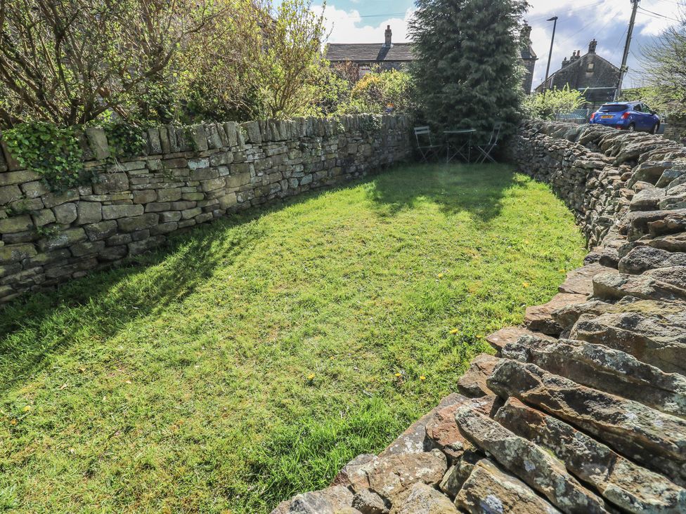 A garden with stone wall and seating area at Moorview in Holmfirth