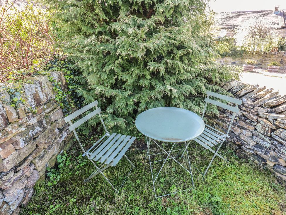 A table and two chairs in a garden at Moorview Holmfirth
