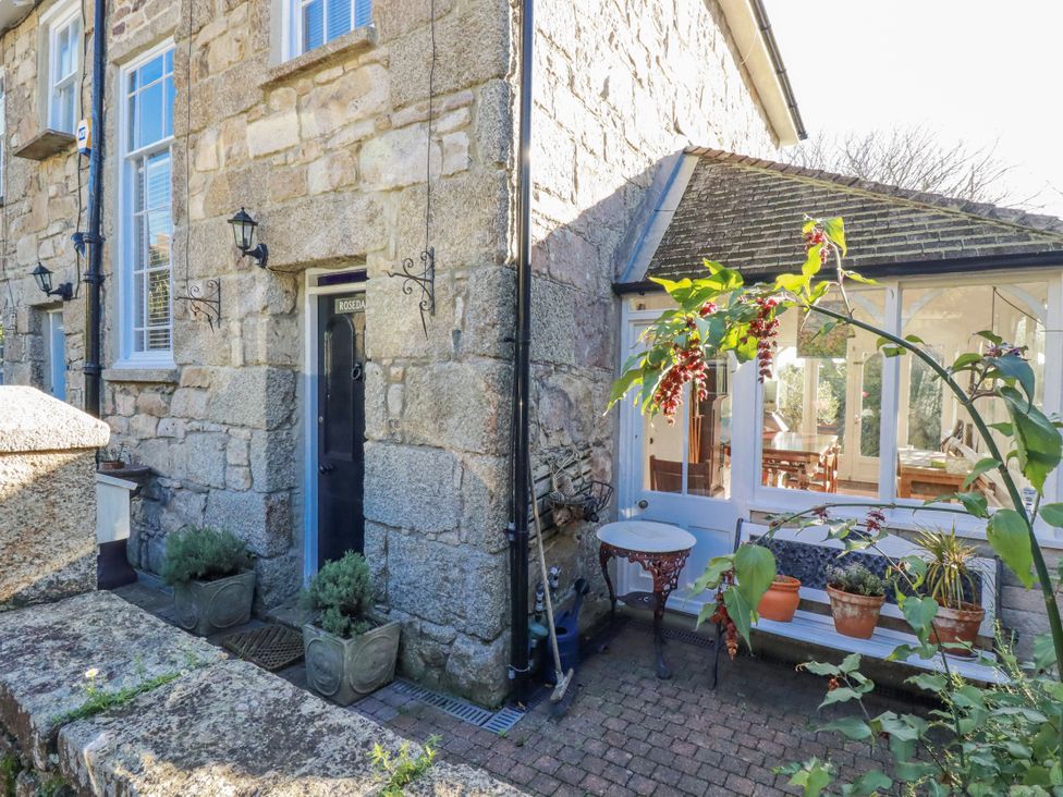 An outdoor area with a stone wall and potted plants at Rosedale in St. Ives