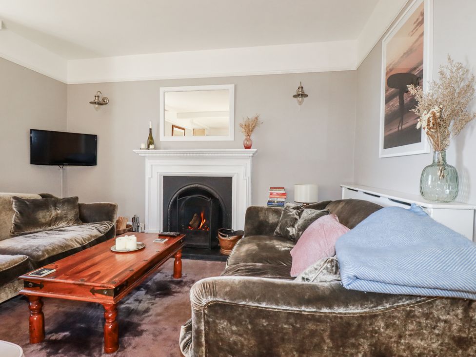 A living room with a fireplace and television at Rosedale in St. Ives