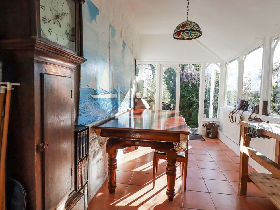 A conservatory with a table and chairs at Rosedale in St. Ives