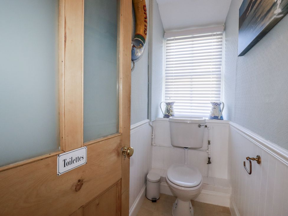A toilet with a window and vases at Rosedale in St. Ives