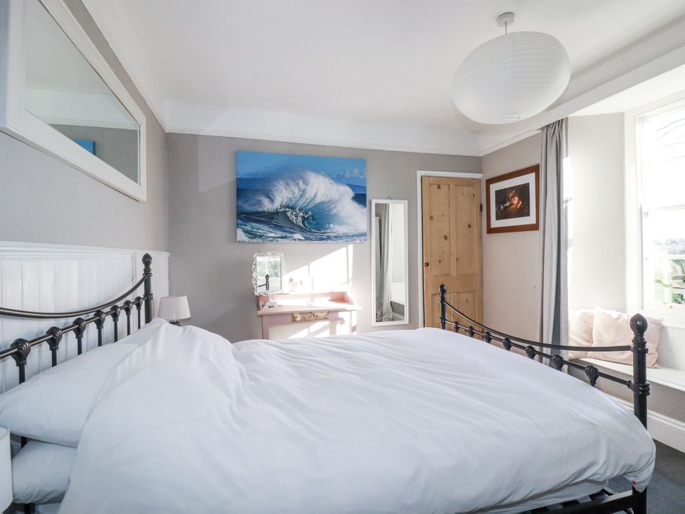 A bedroom with a bed and a table at Rosedale in St. Ives